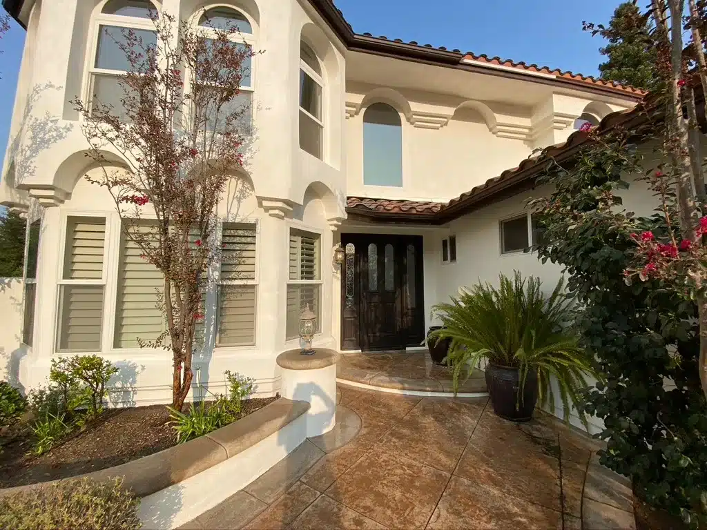 Entryway Exterior Painting and Trim in Simi Valley California A grand residential entryway with an arched dark door and decorative trim in Simi Valley California.