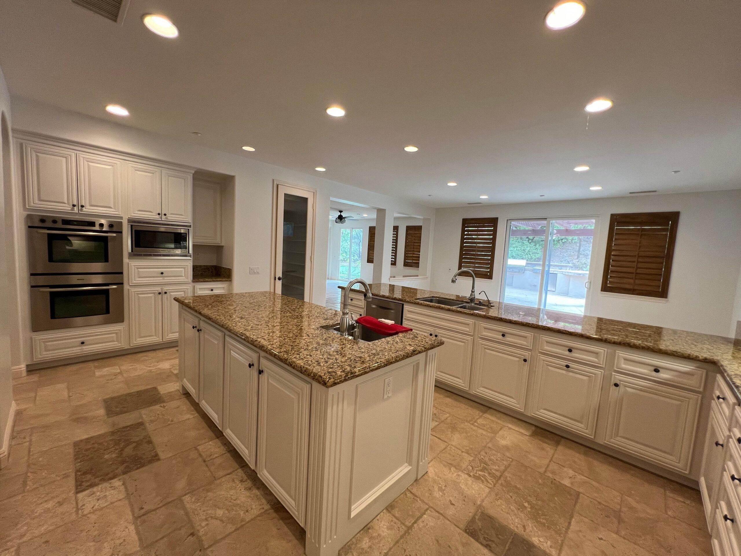 Cream Kitchen Cabinets With Granite Island Cream-painted kitchen cabinets with granite countertops, center island, stainless steel appliances, and recessed lighting
