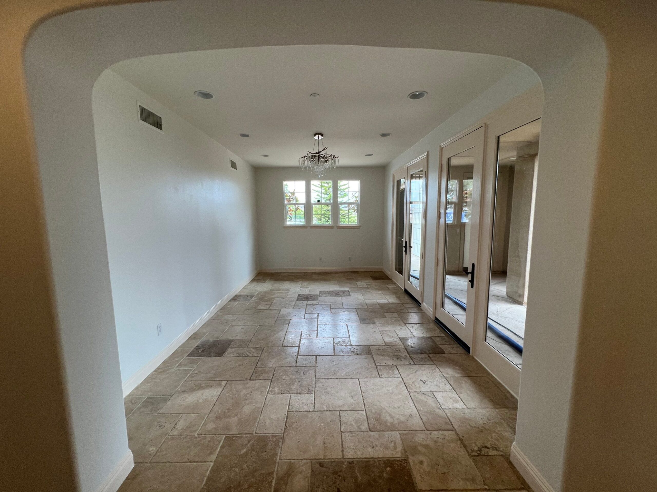 White Painted Interior Room White painted interior room with travertine tile floor, recessed ceiling lights, and glass-door closets in residential home